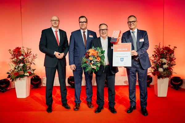 Lübbenaus Bürgermeister Helmut Wenzel nimmt Auszeichnung zur Kommune des Jahres 2025 entgegen